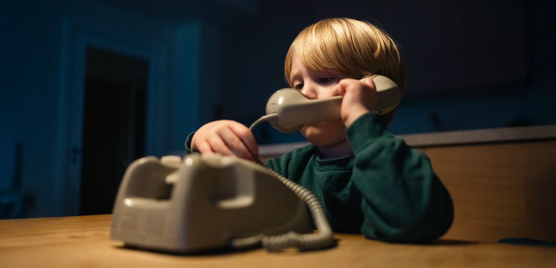 Barn holder i en gammel telefon