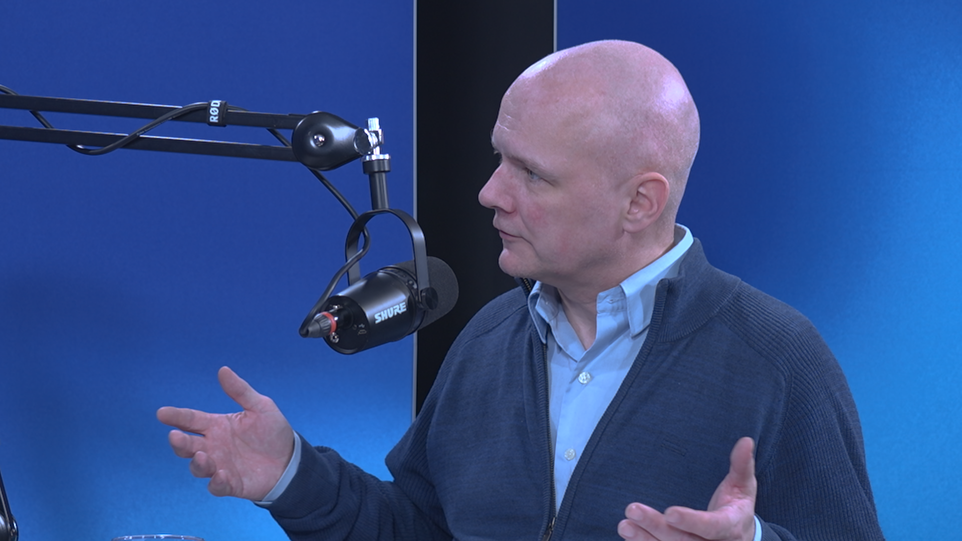 Person foran mikrofon i et studio, mulig podkast-innspilling