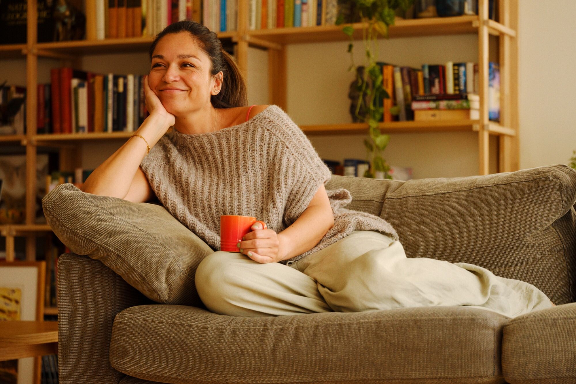 Person med svart frakk og lyseblått skjerf holder en mobiltelefon