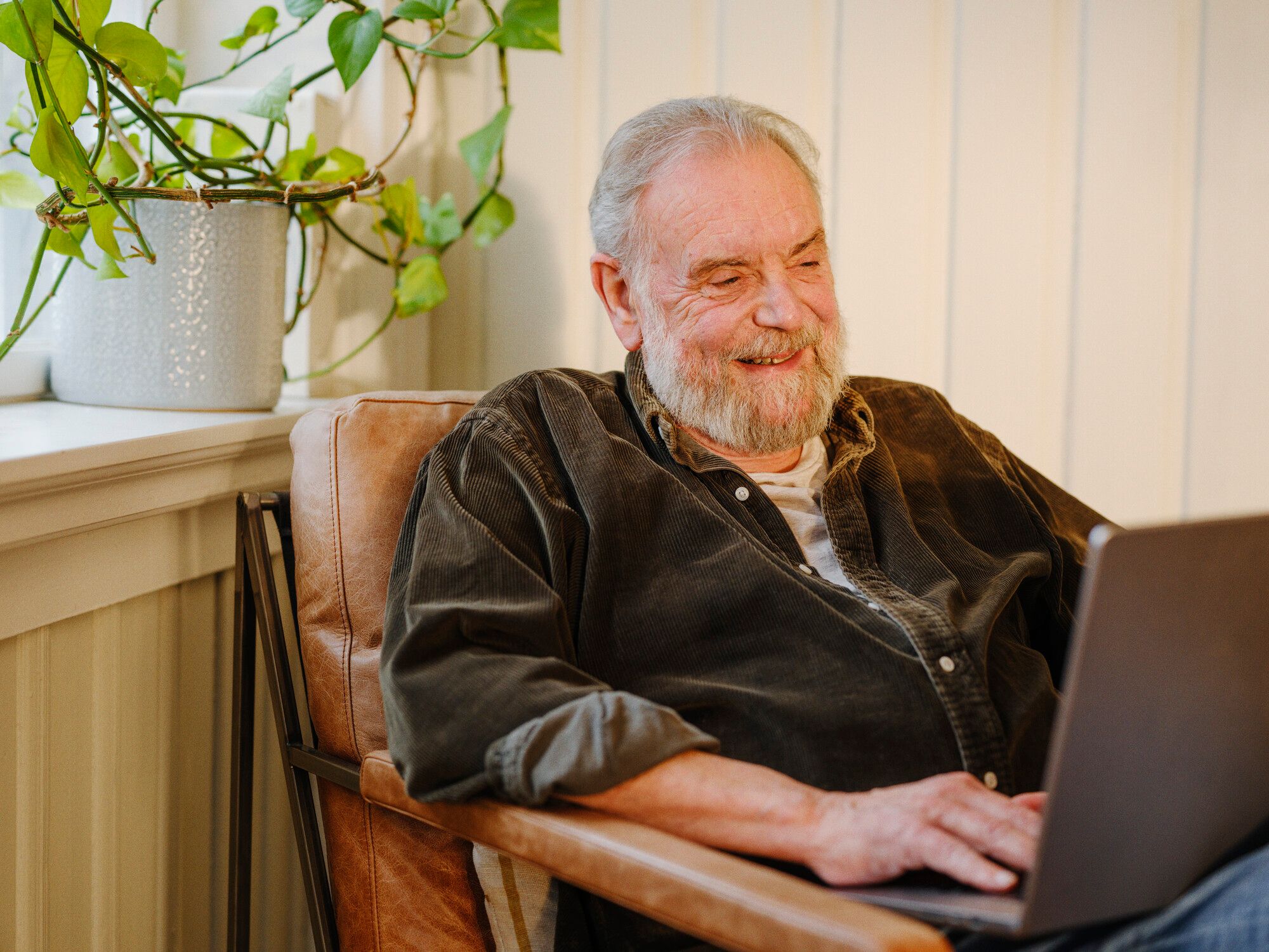 Person sitter avslappet med en bærbar PC i et lyst rom