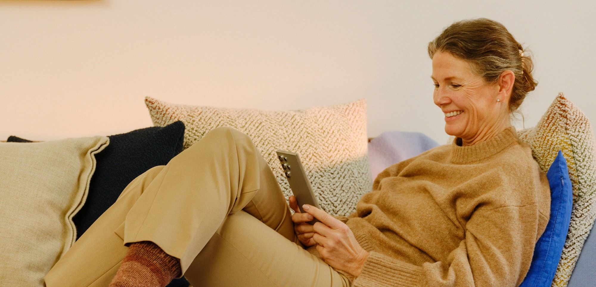 Dame i sofa som laster opp bilder i Min Sky