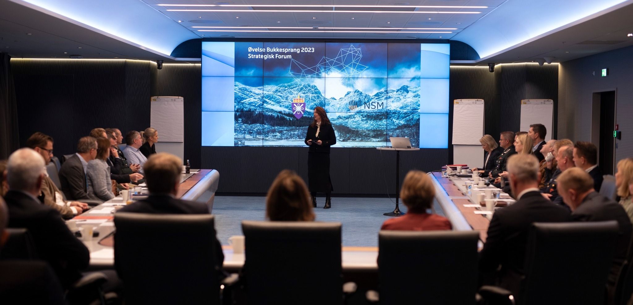 Programmerer jobber ved skrivebord med flere skjermer