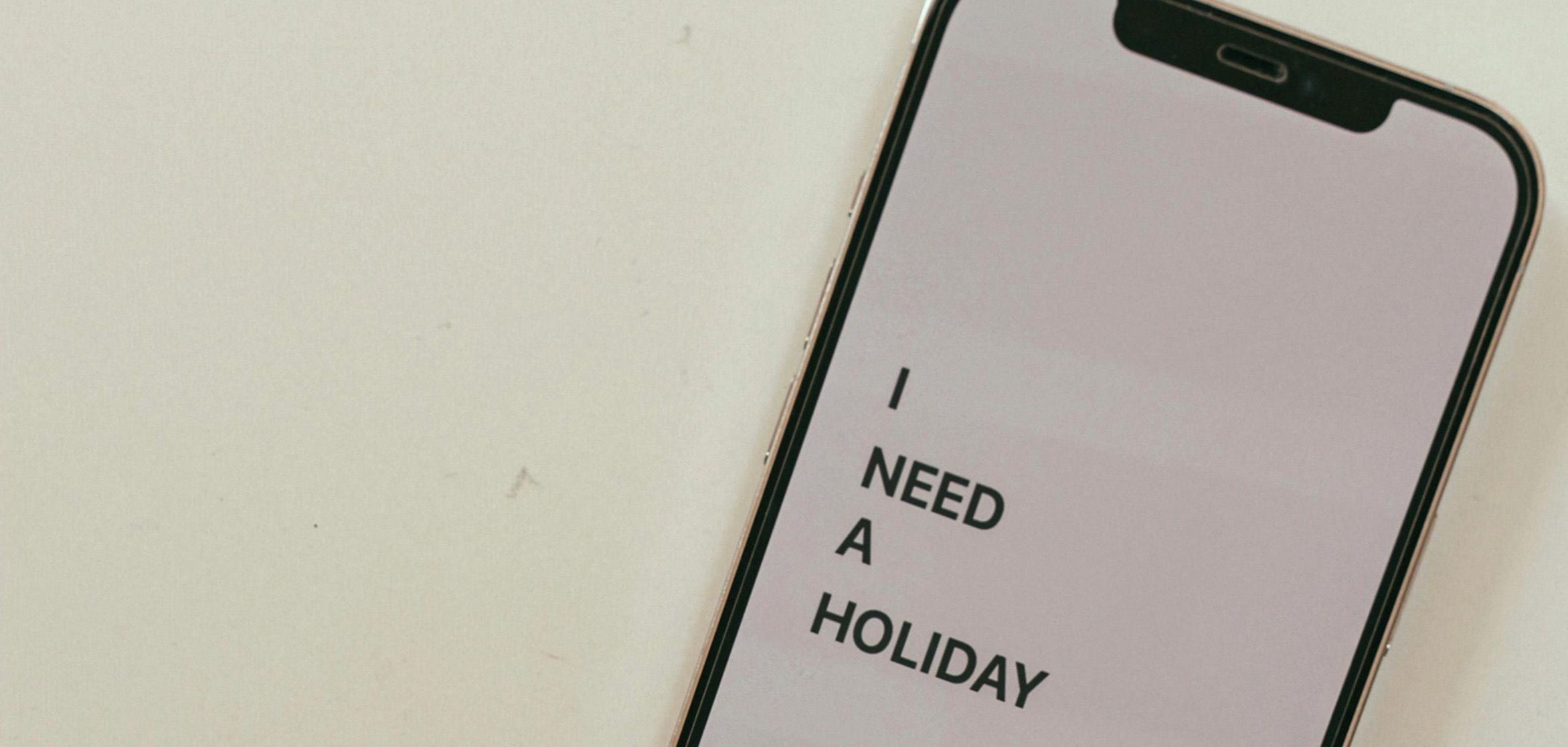 Mobilskjerm sier "I NEED A HOLIDAY"