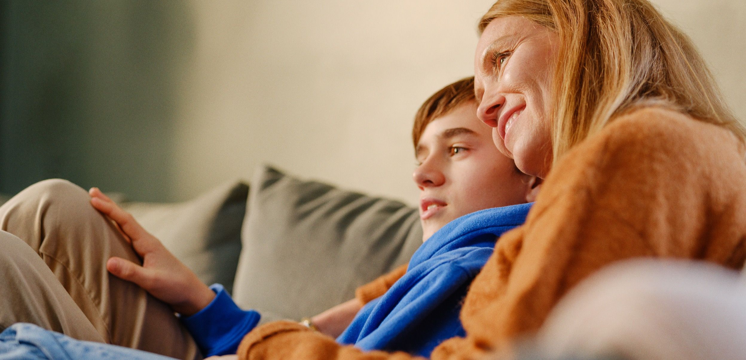 To personer sitter sammen på en sofa, avslappet og nær hverandre