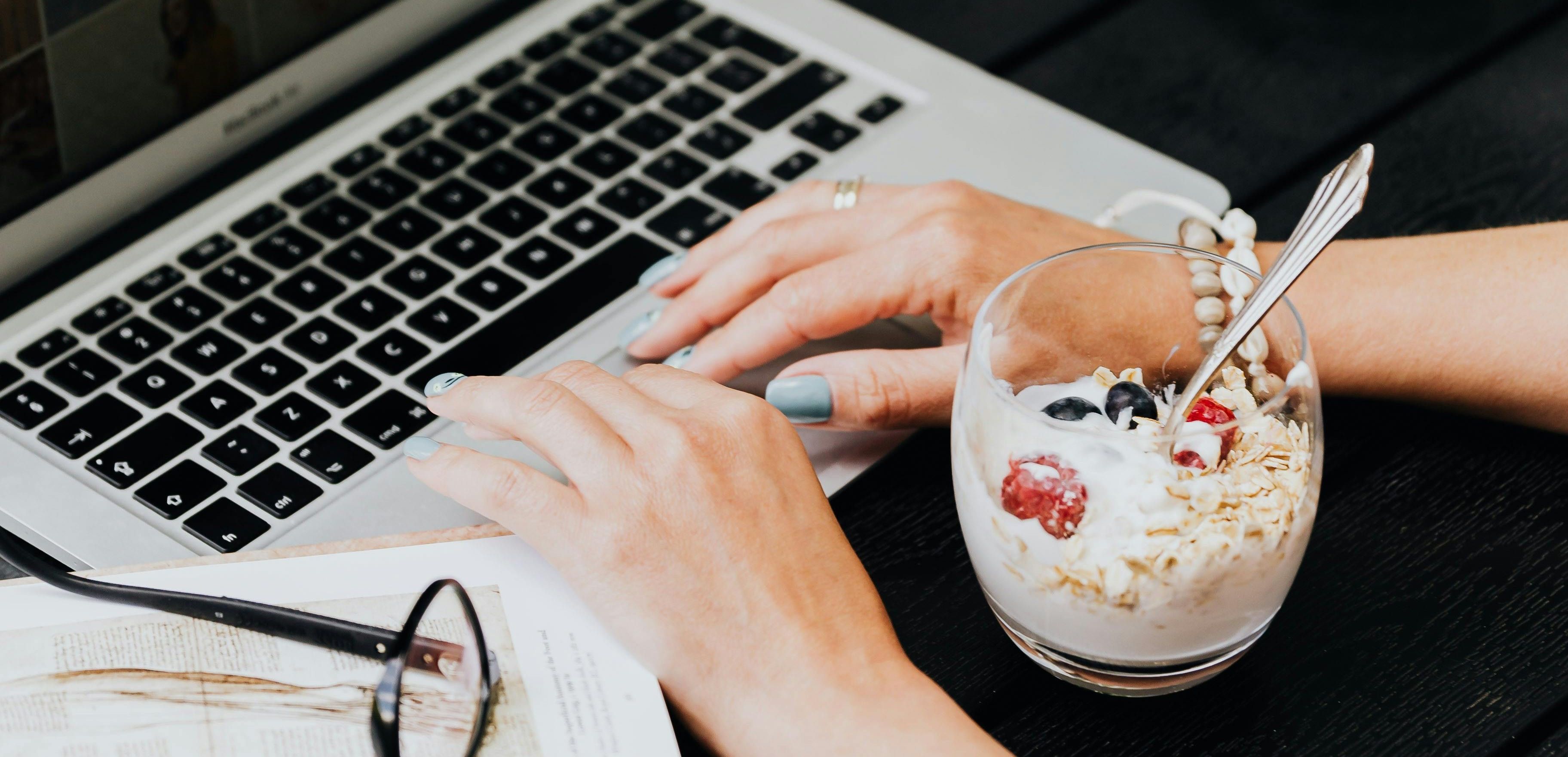 Arbeidsfrokost med laptop og yoghurt