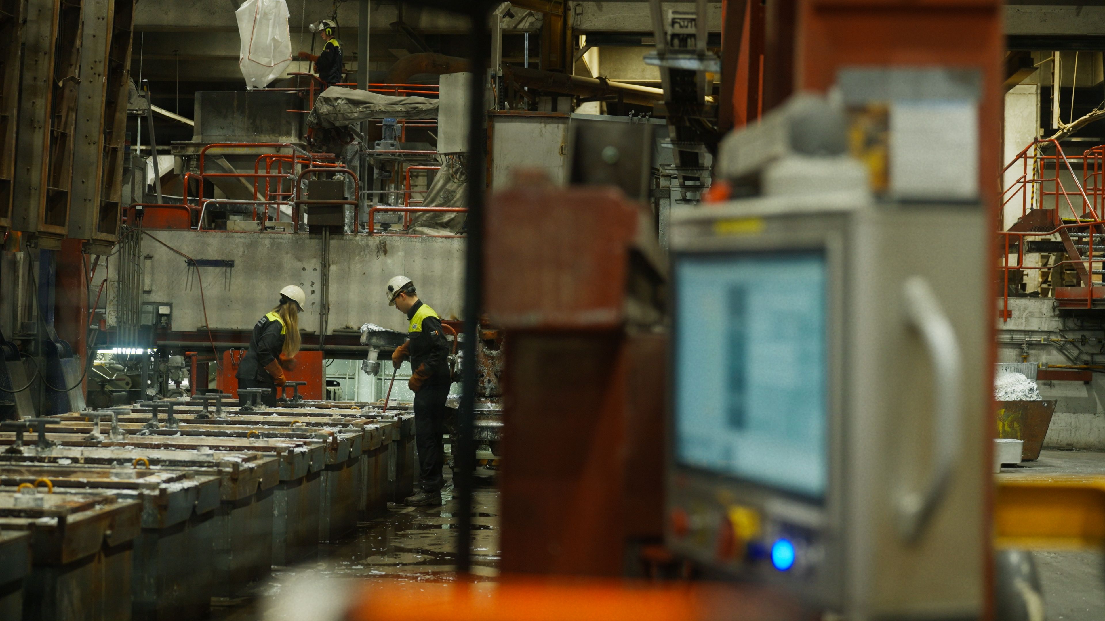 Arbeidere med verneutstyr i en metallindustriell fabrikksetting