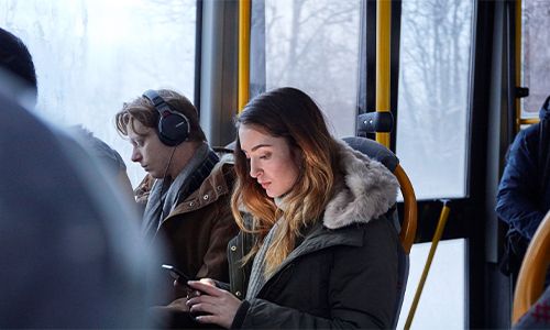 Kvinne på mobil på bussen