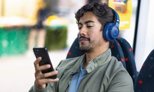 Mann som sitter på bussen med en mobil