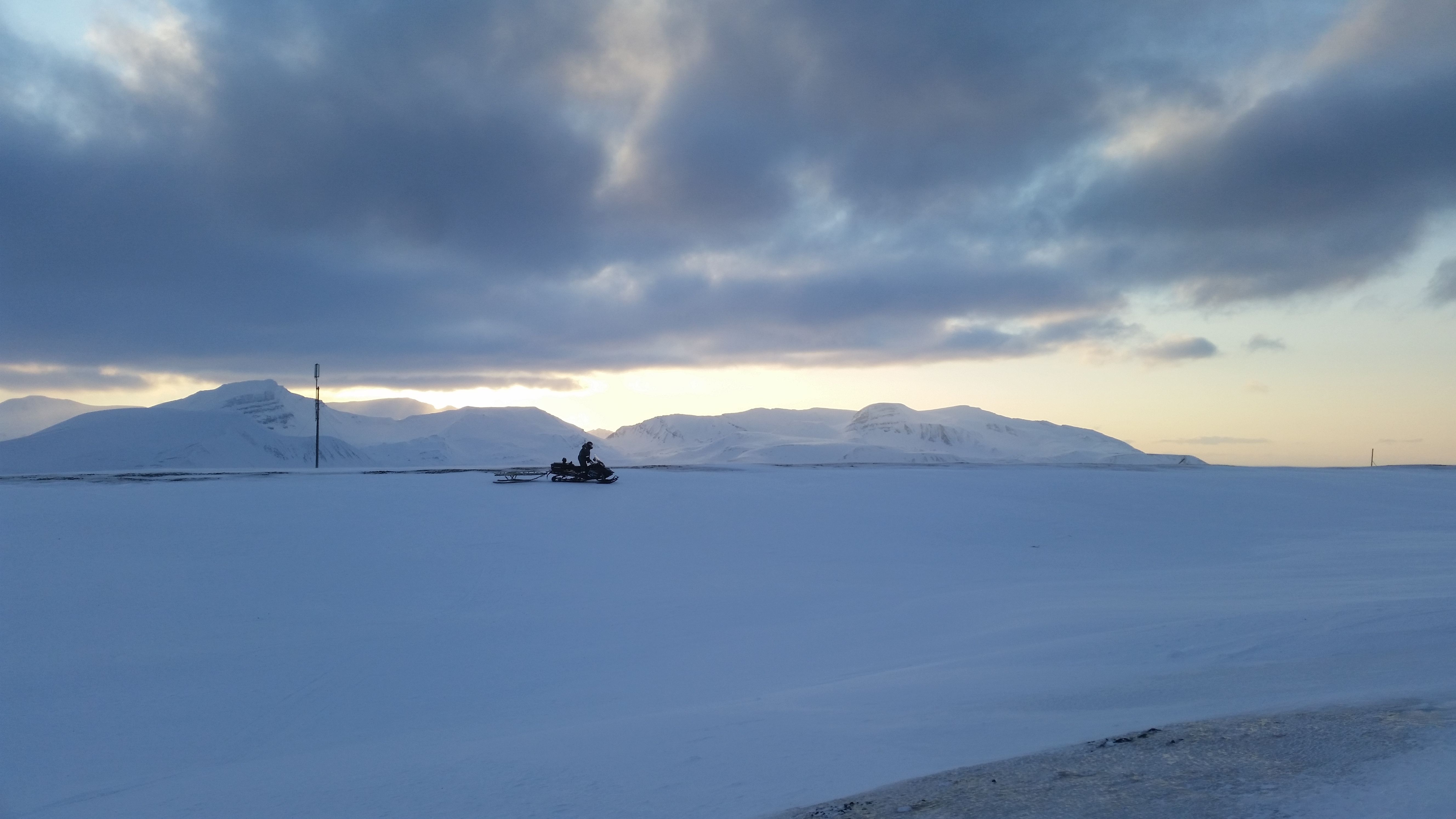 Mann går mot telekommunikasjonsmast på steinete landskap