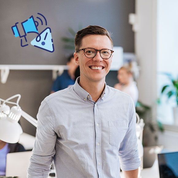 Ung mann i lys skjorte på kontor med varselsymbol i luften