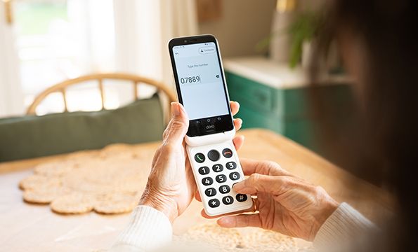 en eldre dame som skriver på sin doro mobiltelefon