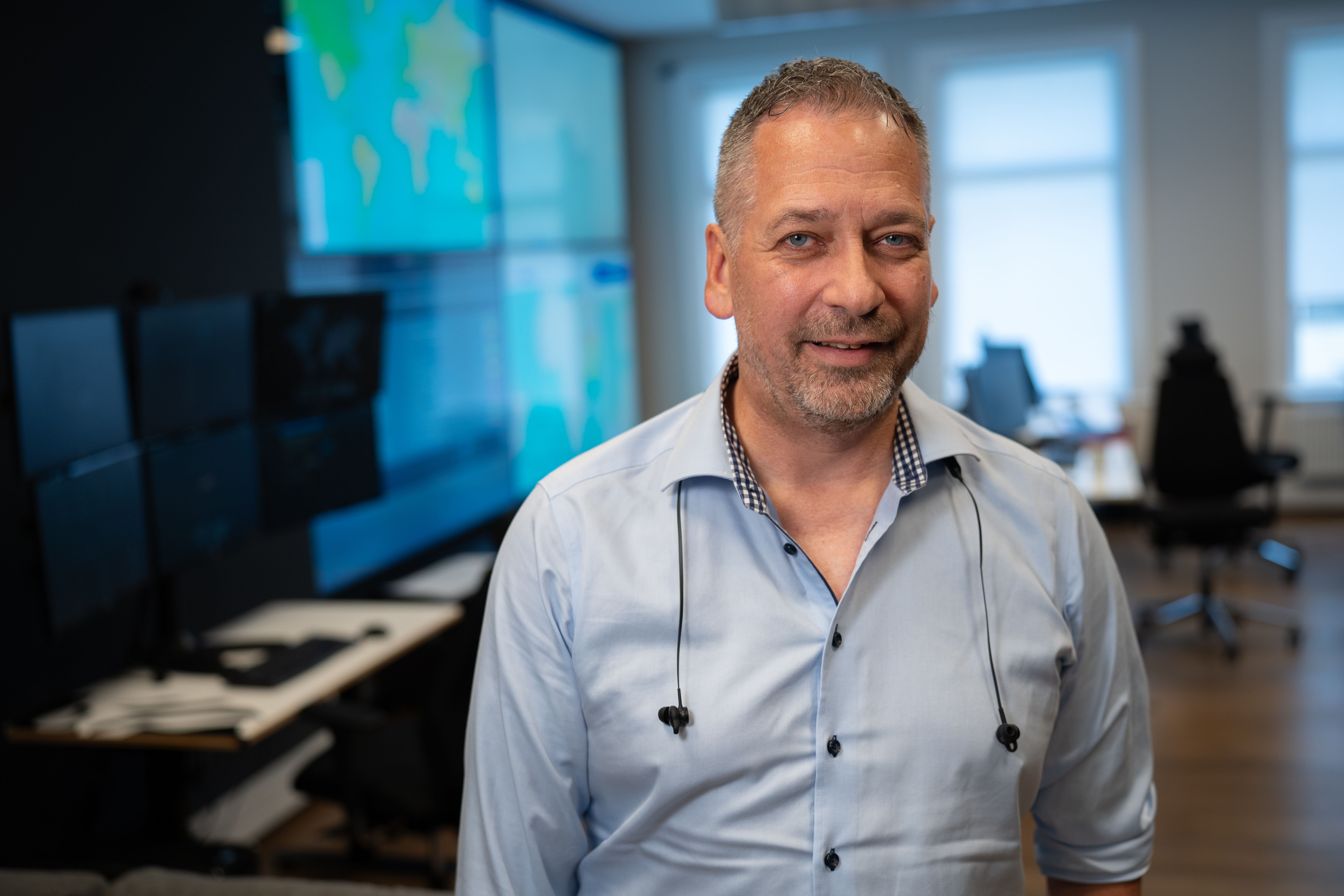 Person med lyseblå skjorte i et moderne kontorlokale