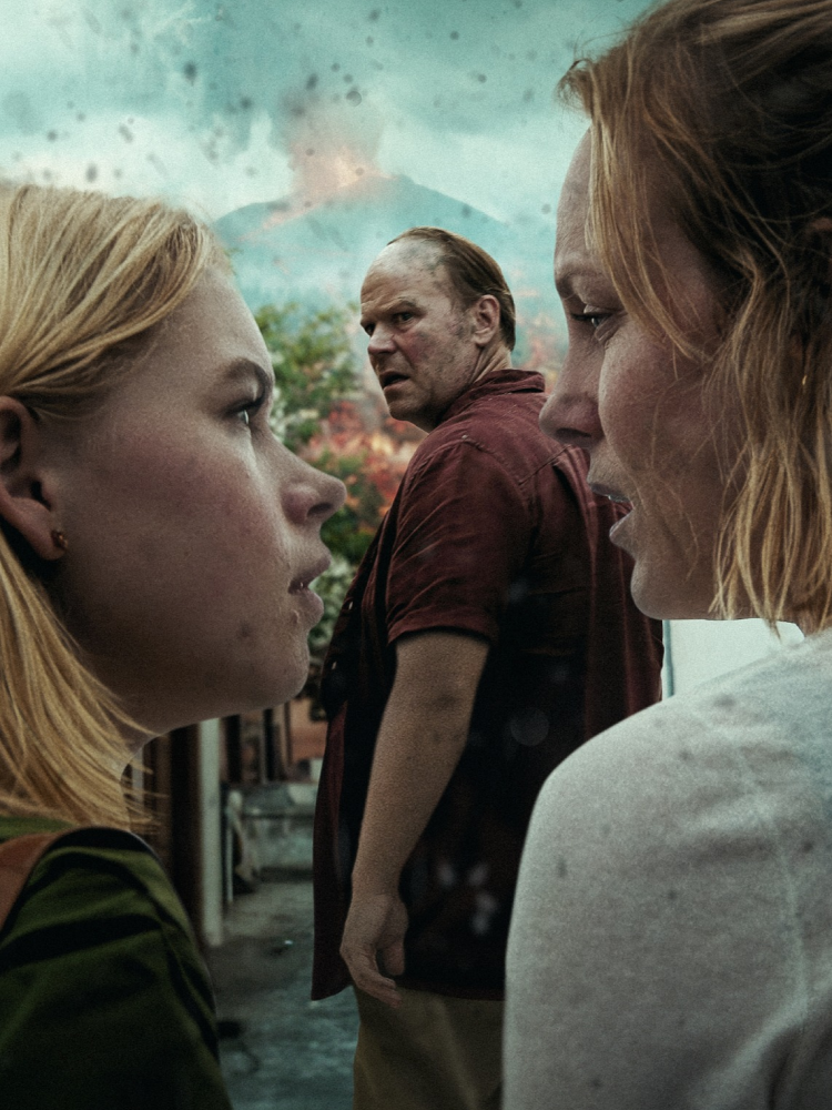 Familie ser på hverandre mens en vulkan bryter ut