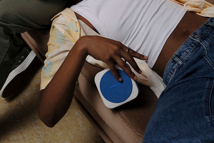 Person som slapper av med en polaroid music player 1 bærbar høyttaler i hånden