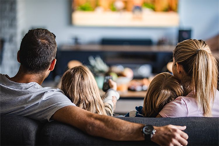 Bilde av noen som ser på T-We i sofaen.