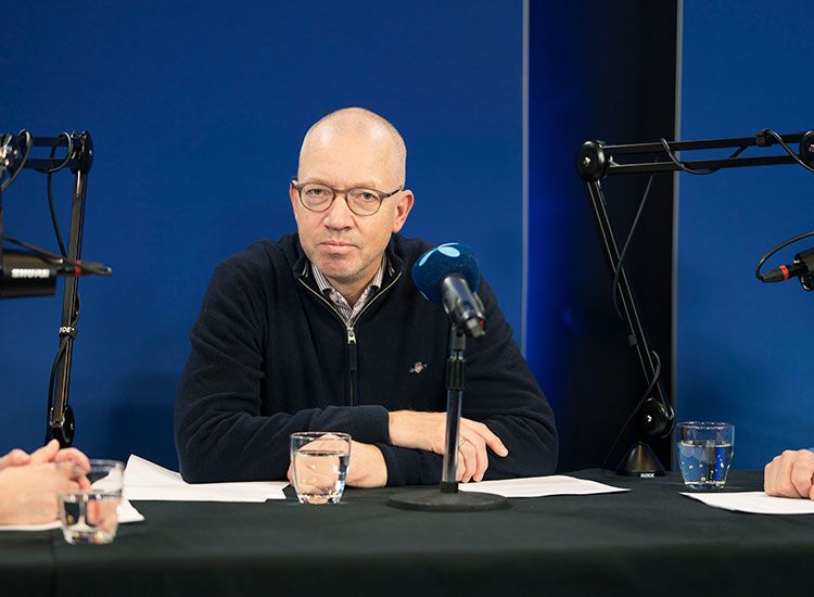 Personer snakker i studio med mikrofoner, podkast-opptak