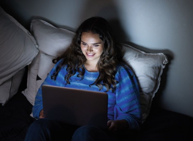 Person med en bærbar datamaskin i dempet belysning