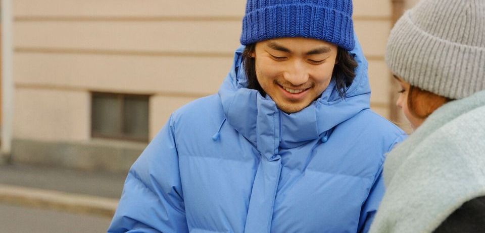 To personer i varme klær med kaffekopper utendørs