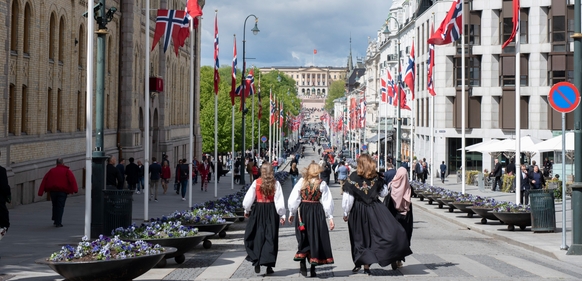 Karl Johans gate pyntet med norske flagg og folk i bunad