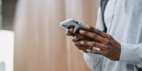 Mann med mobil i hendene som sjekker dataforbruket på apper