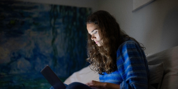 Ung kvinne som rydder i innboksen på laptop