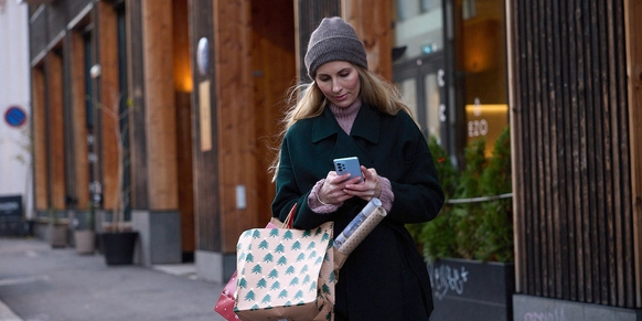 Dame på juleshopping med mobil og ubegrenset data