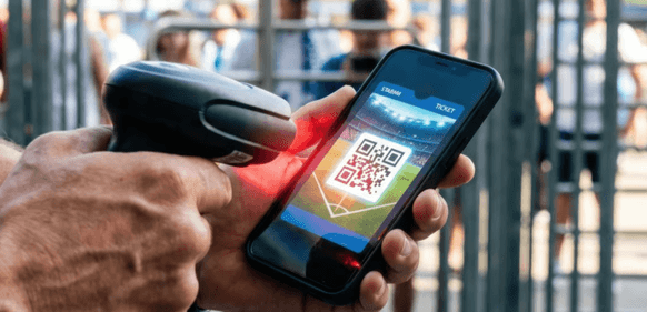 Mobilbillett som blir scannet foran en festival