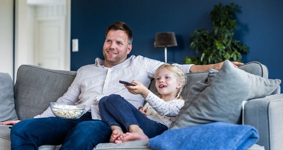 Bilde av familien som ser på TV hjemme.