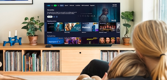 Bilde av mor og sønn som ser på TV fordi de vet hvordan aktivere strømmetjenester. 